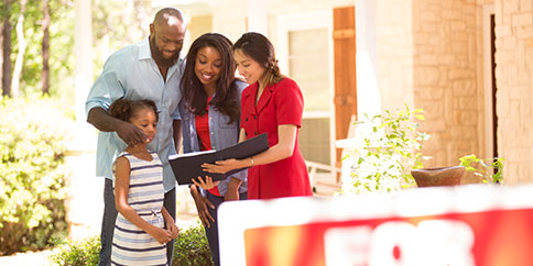 Real estate agent outside of home with a family